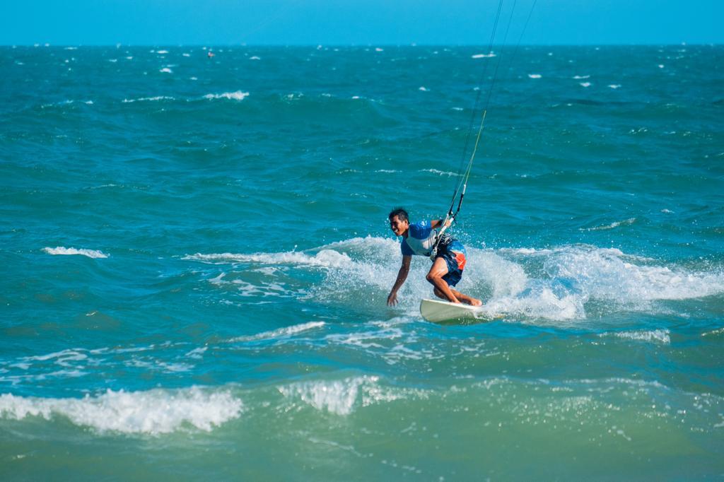 Lý kitesurfing on a bright turquoise sea in Mui Ne