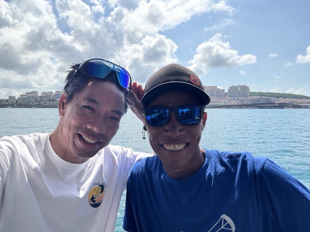Lý and a friend smiling on the beach holding a kite bar