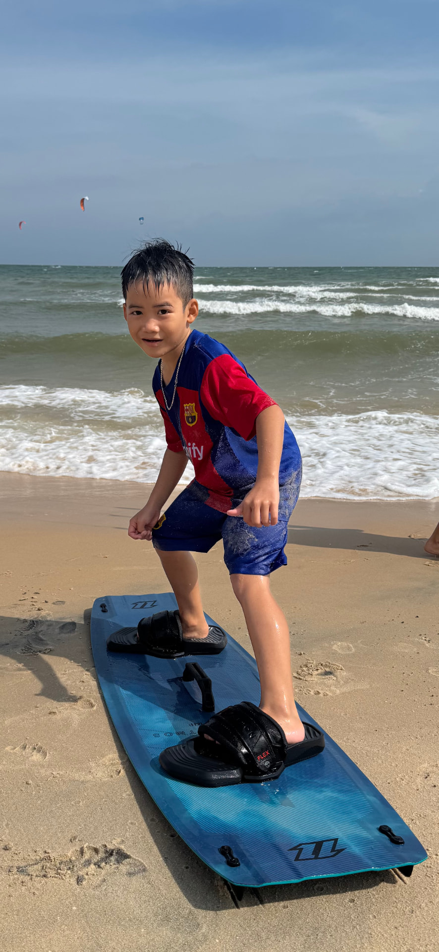 Young student standing on a kiteboard on the beach