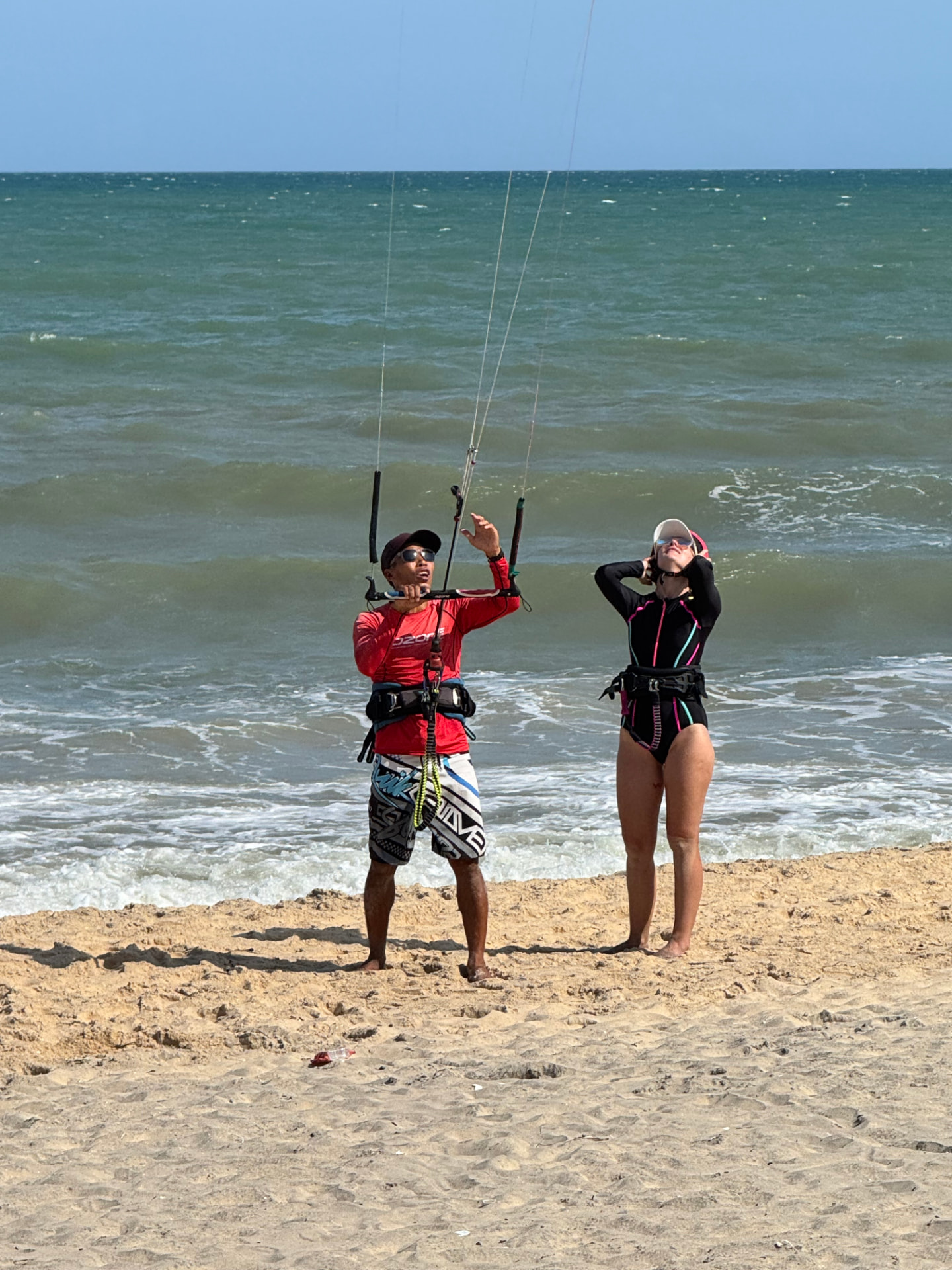 Lý showing a student how to launch a kite on the beach